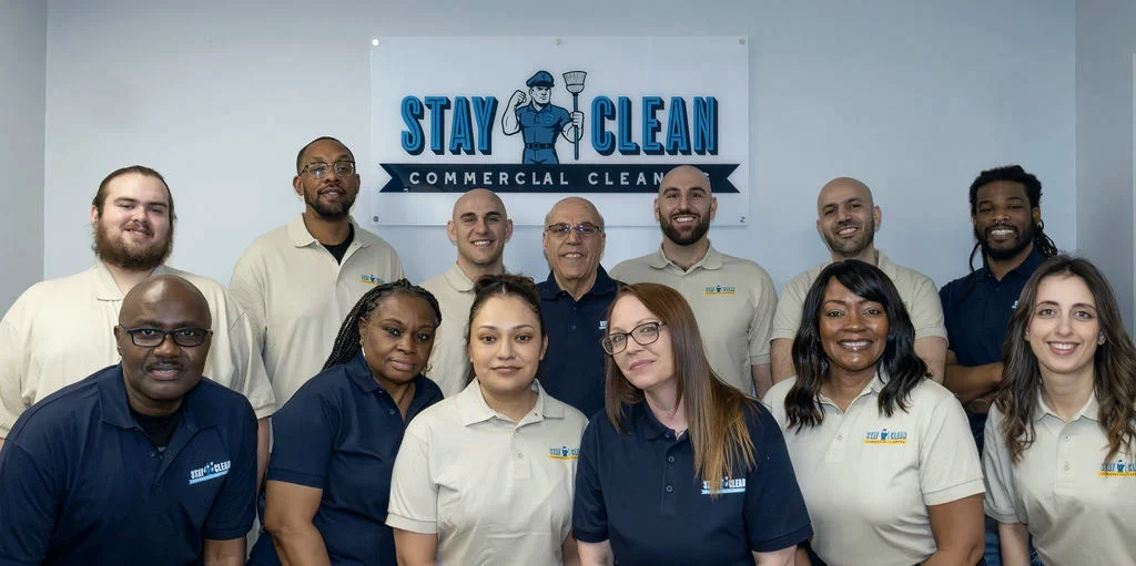 The full Stay Clean Solutions team in front of the company sign